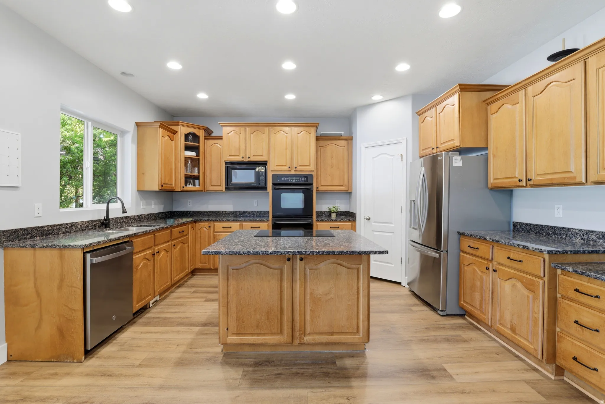 Kitchen featuring wood-finish flooring, recessed lighting, and light wood cabinetry with dark hardware