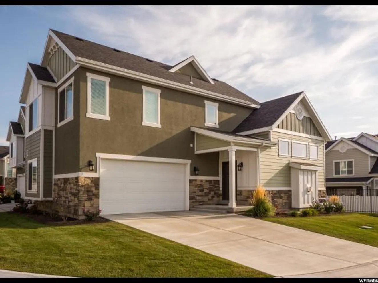 Craftsman inspired home with stone siding, an attached garage, board and batten siding, concrete driveway, and roof with shingles