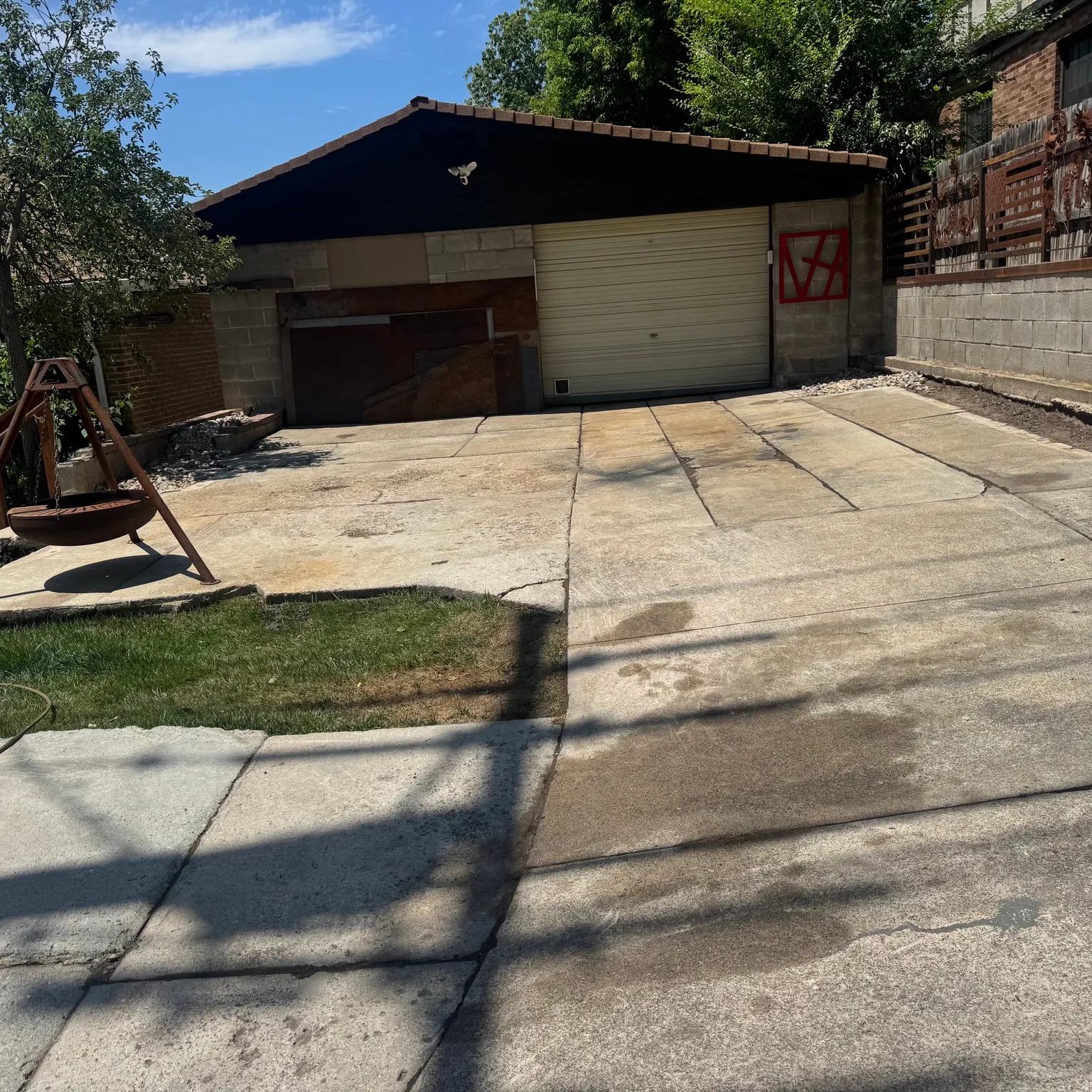 Detached garage structure with a concrete block base, a light-colored roll-up garage door, and an additional smaller entry