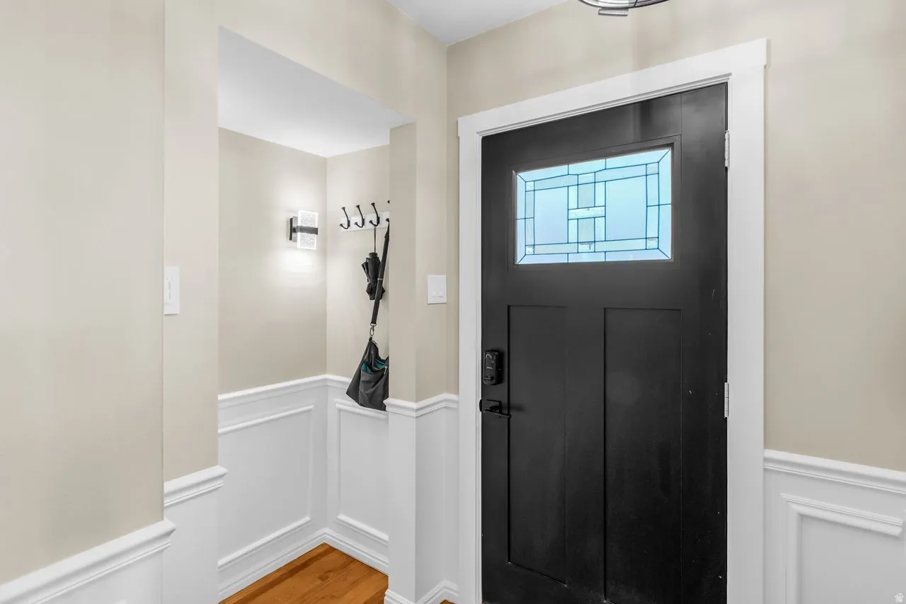 Entryway featuring a black paneled door with a decorative glass insert, white trim, and light beige wall paint