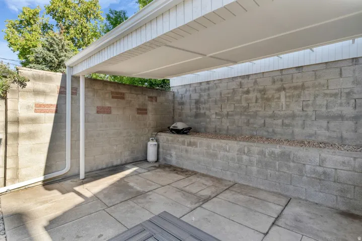 Covered patio area featuring a block wall surround with integrated planter and concrete paver flooring