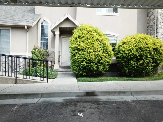 Stucco exterior featuring stone accents and a covered entryway