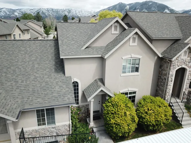 Stucco and stone facade home featuring a prominent peak roofline and architectural gables
