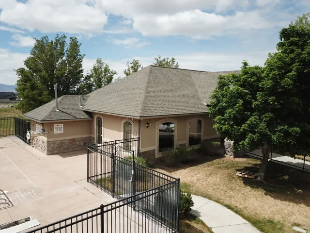 Exterior structure featuring a hip roof, stucco siding, and stone accents