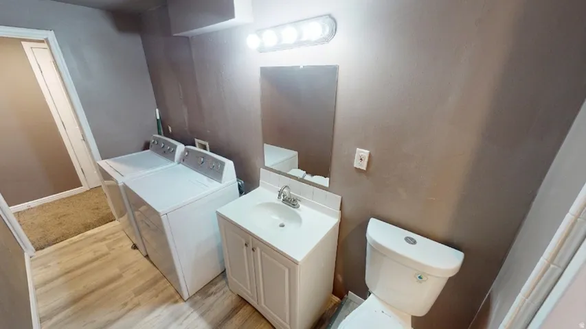 Vanity with integrated sink, wall-mounted mirror, and overhead lighting fixture
