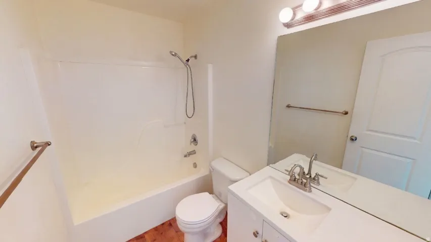 White vanity with undermount sink, chrome faucet, and rectangular mirror