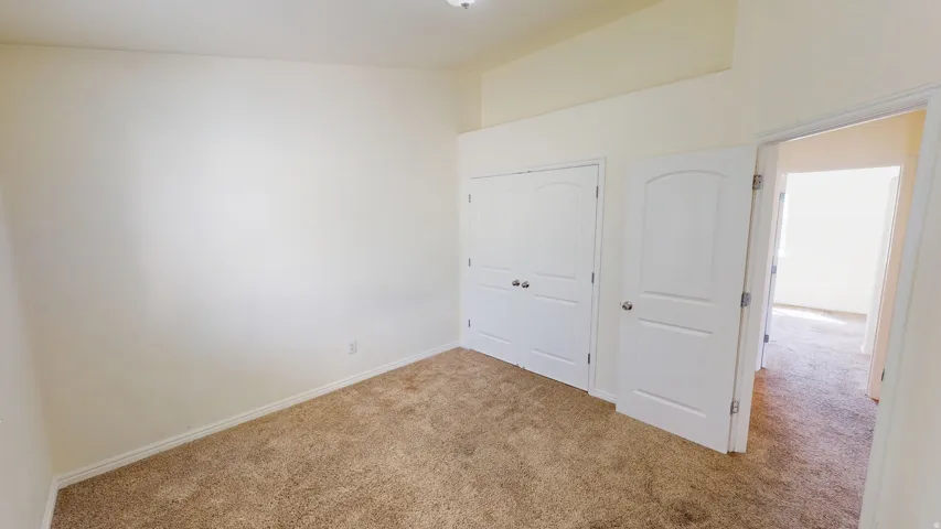 Carpeted flooring, neutral wall tones, white interior doors, and a built-in closet