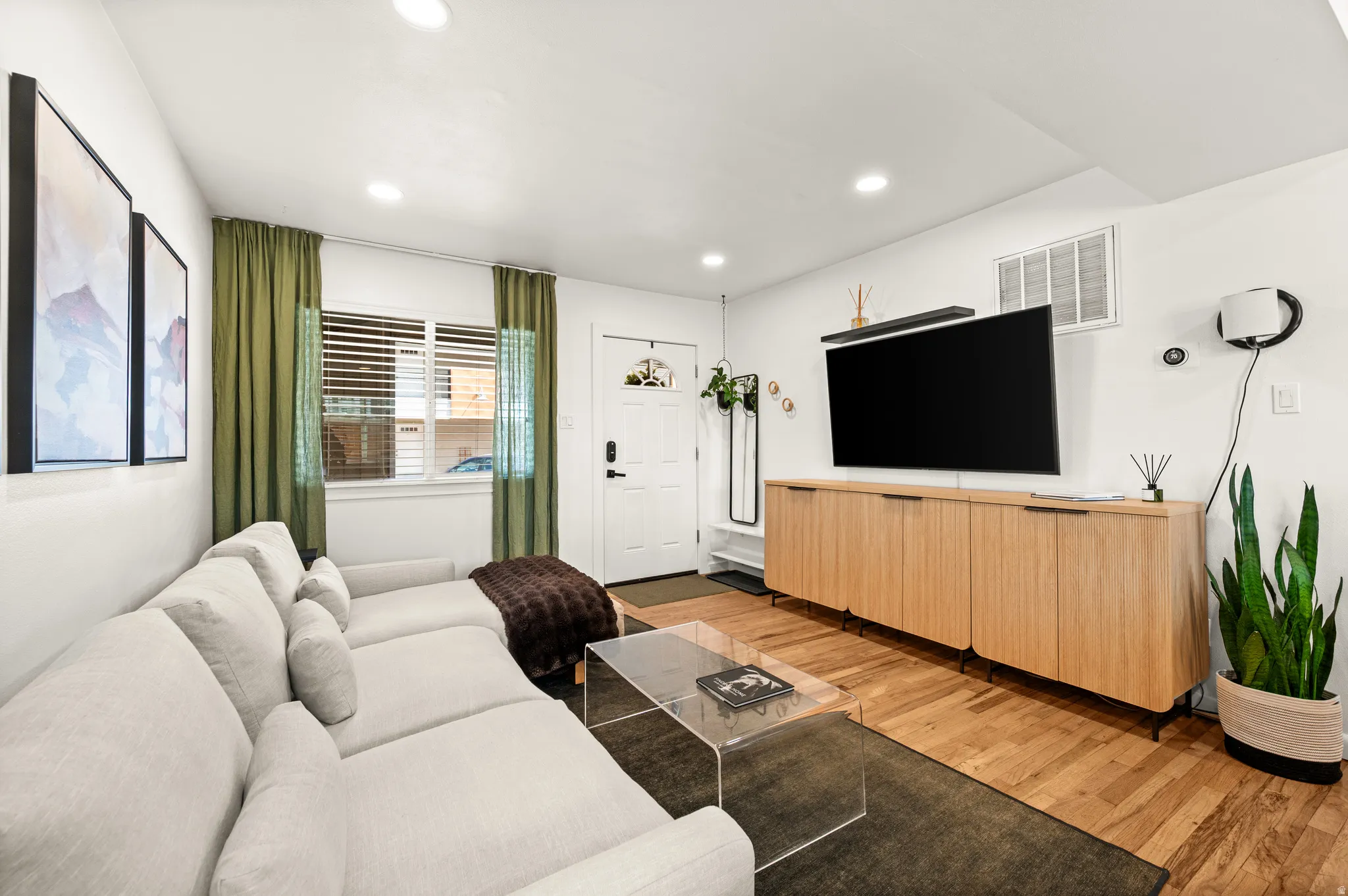Bright living area with wood-finish flooring and recessed lighting