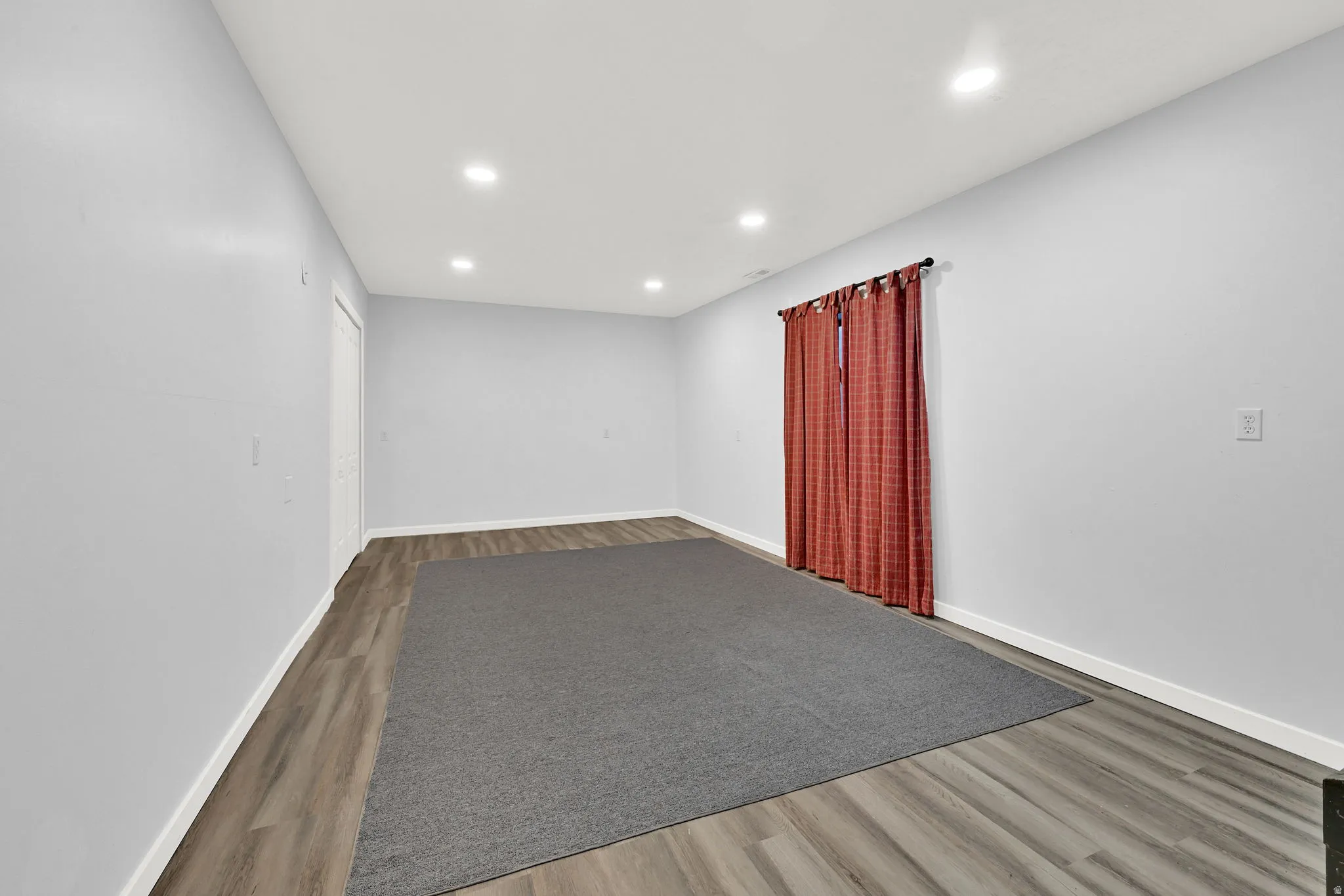 Spacious bedroom #4 featuring wood-finish flooring, recessed ceiling lighting, and light gray walls