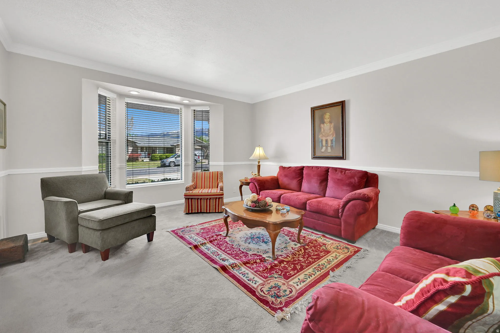 Living area with light gray walls, white chair rail molding, and crown molding