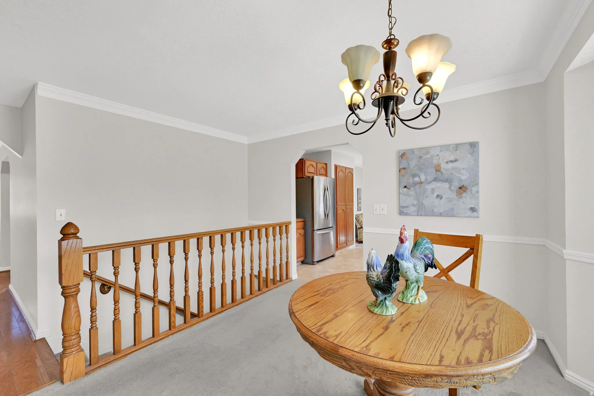 Dining area with a five-light chandelier, crown molding, and chair rail detailing