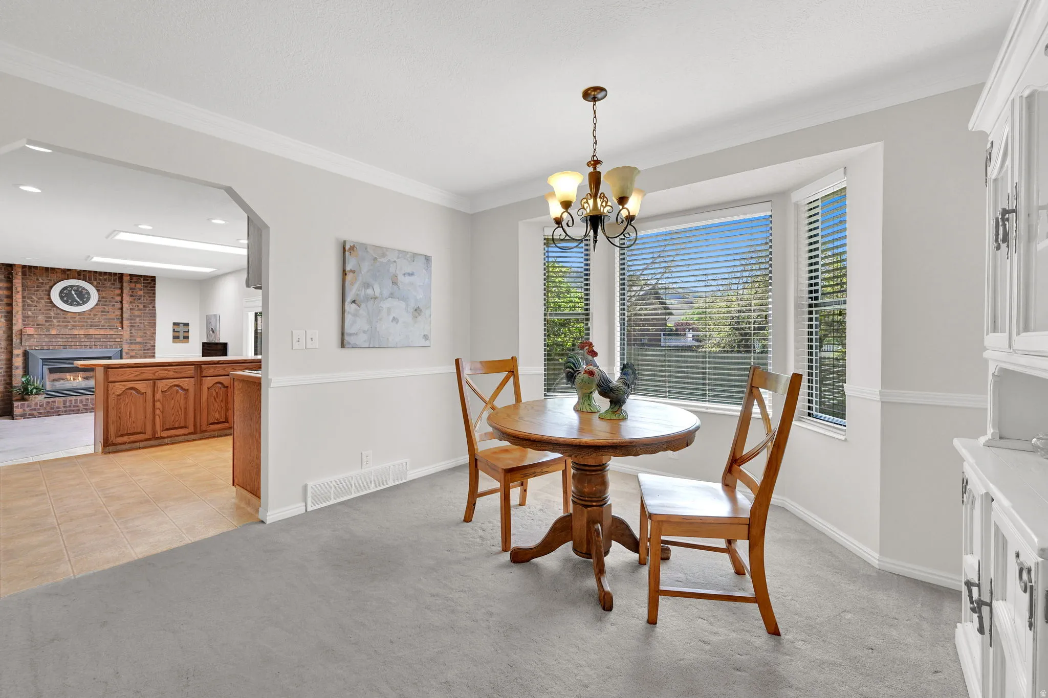 Formal dining space featuring a bay window, crown molding, and chair rail detailing