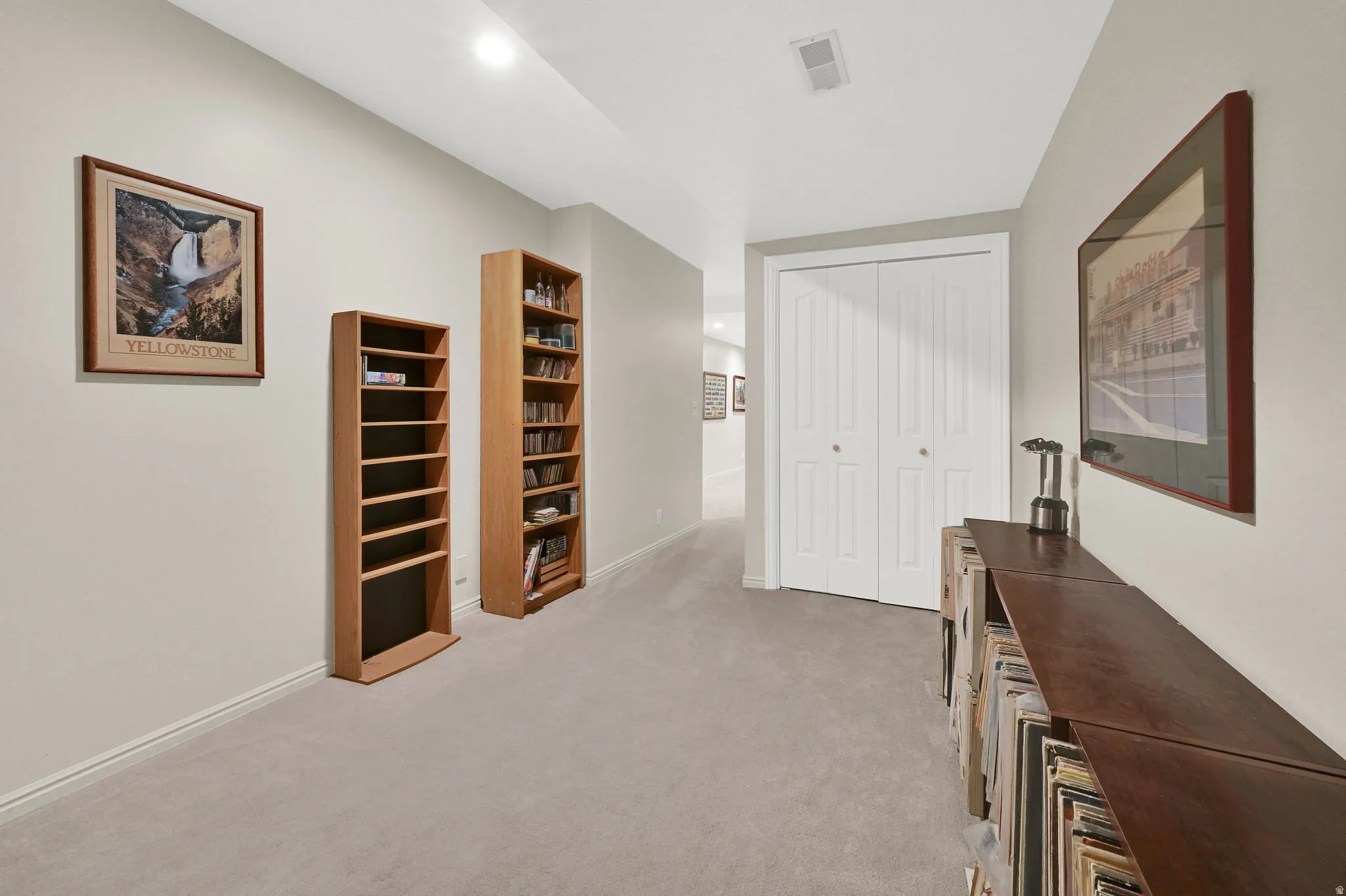 Hallway flex area featuring light gray carpeting, neutral wall paint, and white trim