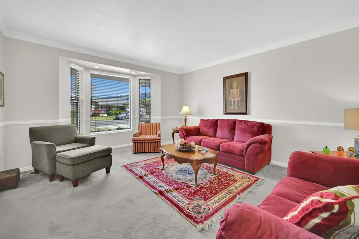 Living area with light gray walls, white chair rail molding, and crown molding