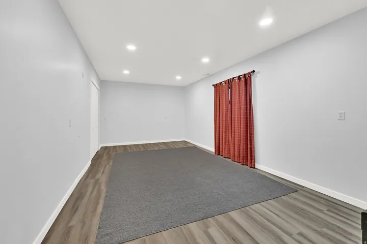 Spacious bedroom #4 featuring wood-finish flooring, recessed ceiling lighting, and light gray walls