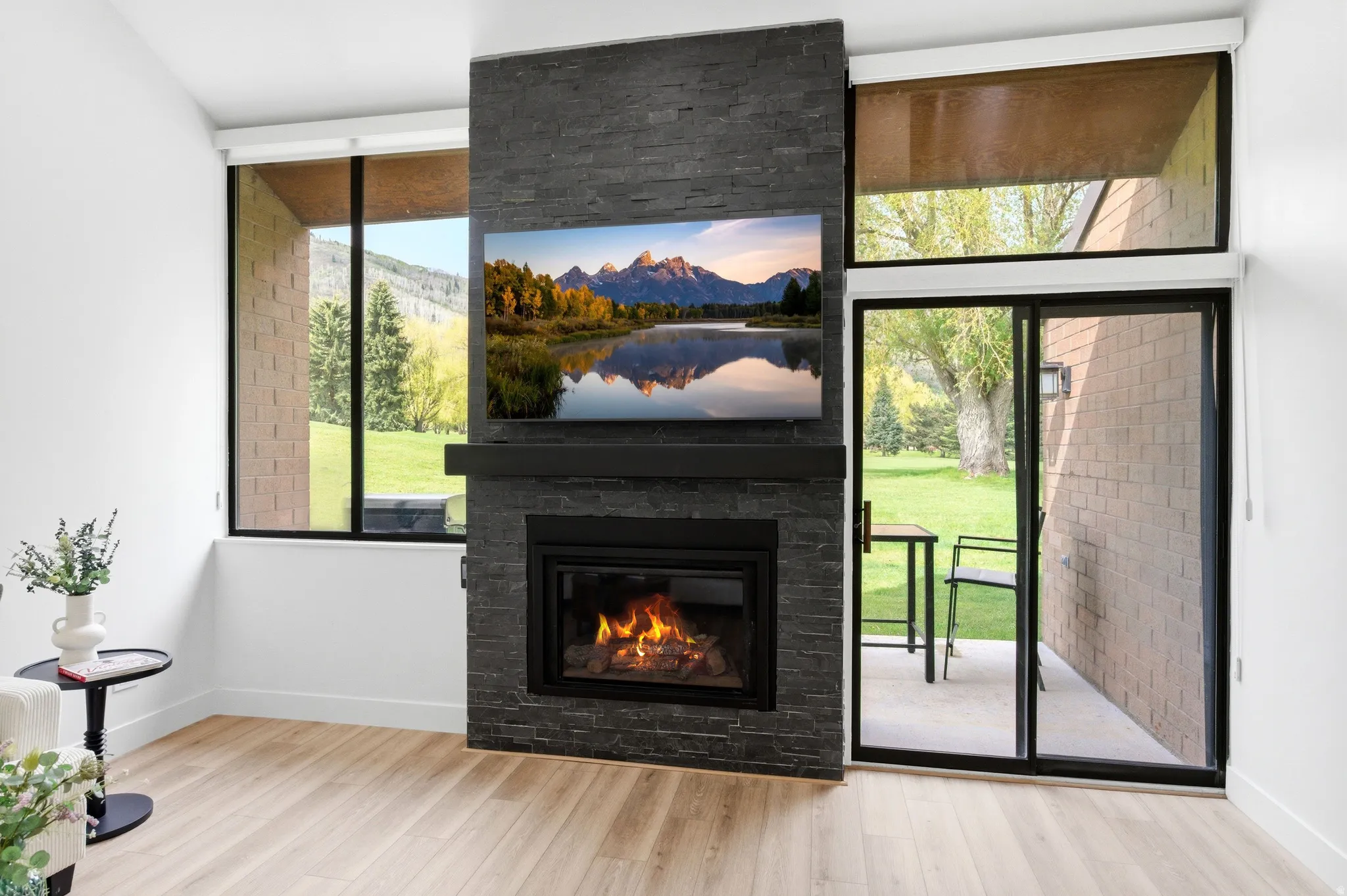 Fireplace with a stone surround and hearth, featuring a built-in television above