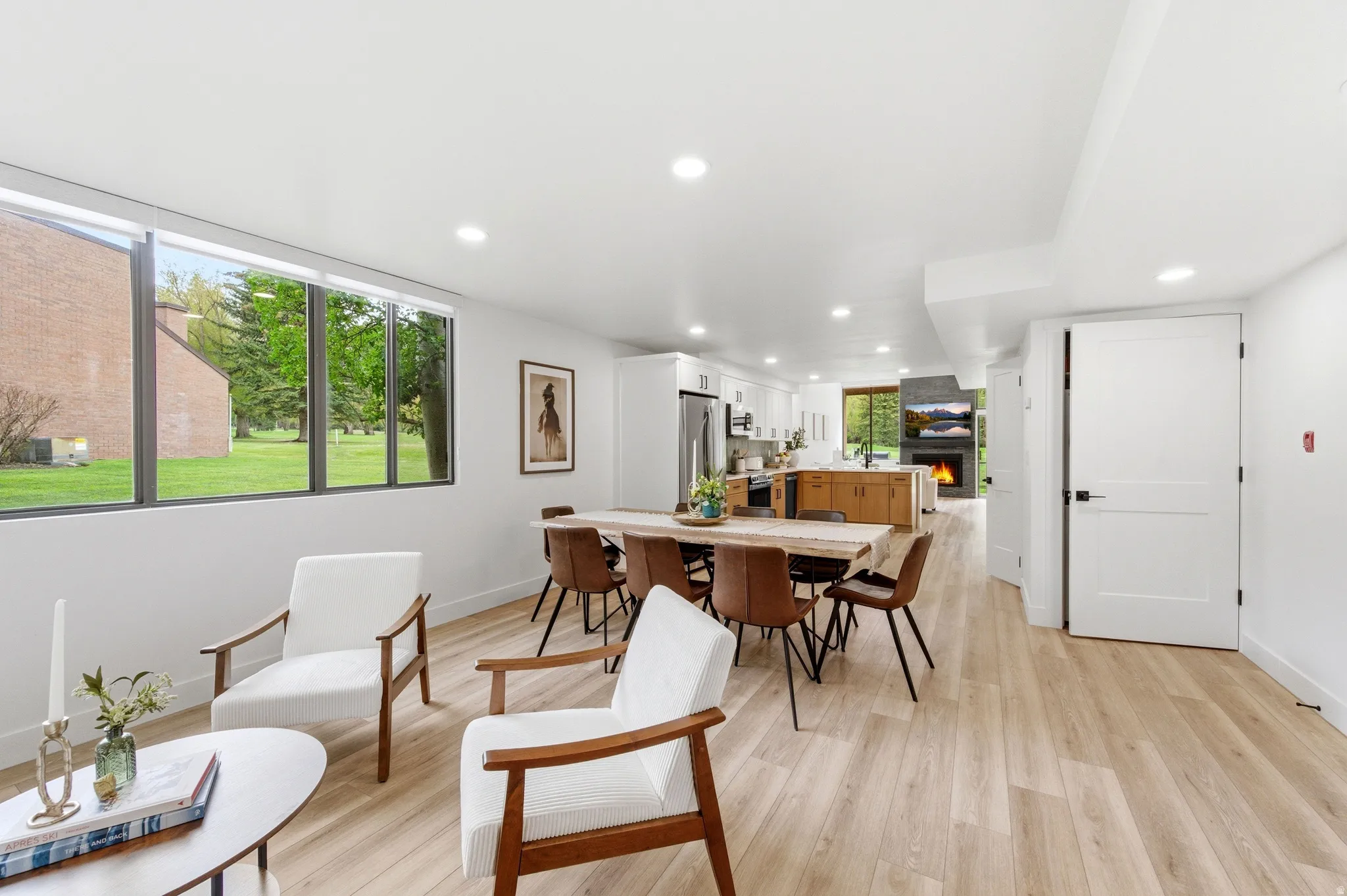 Open-concept living space featuring wood-finish flooring and a wall of windows