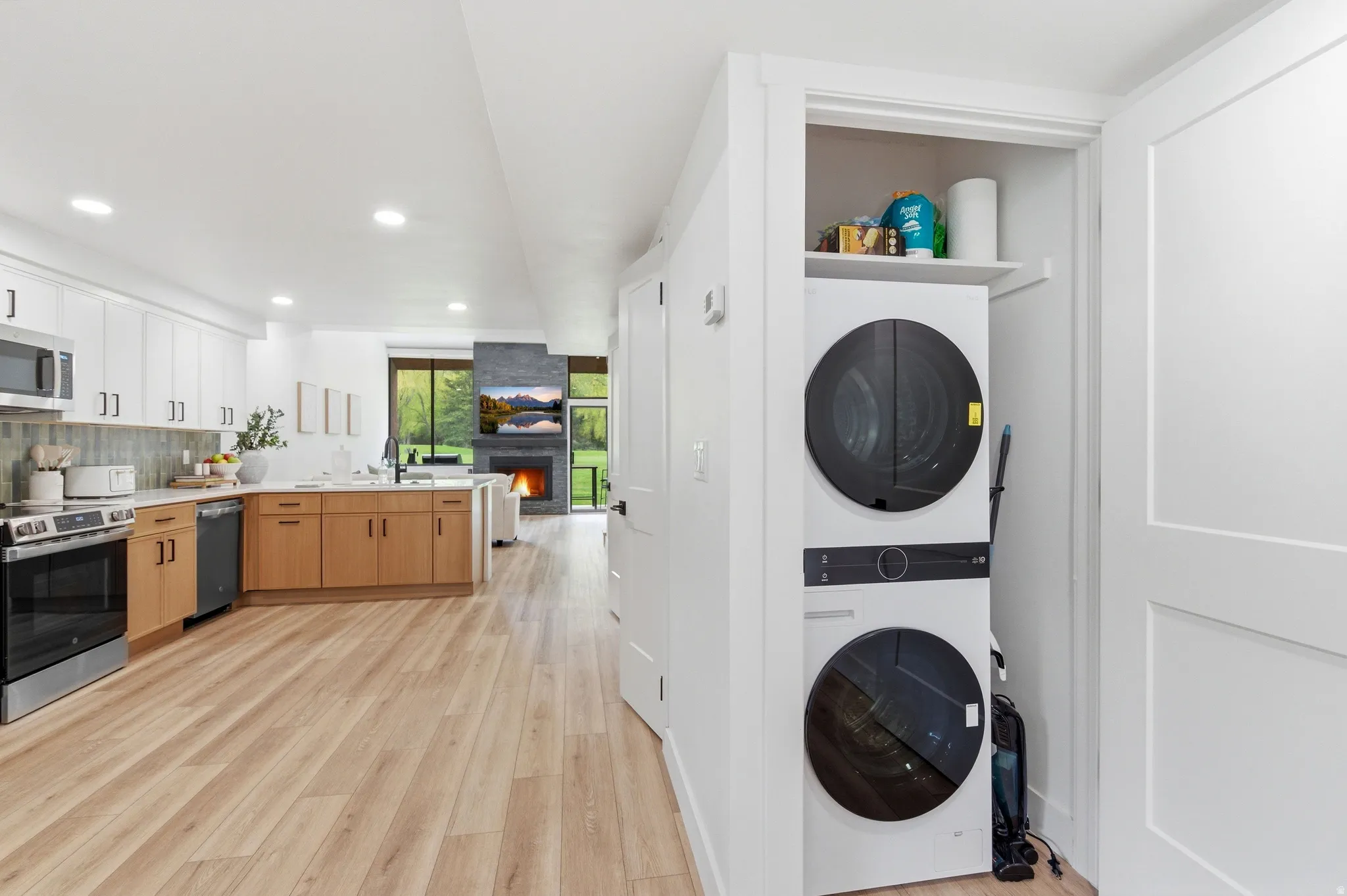 Integrated laundry closet featuring a stacked washer and dryer unit