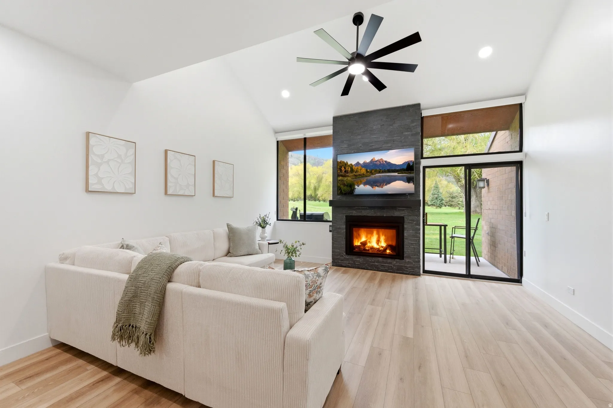 Vaulted ceilings complement the stone-clad fireplace and wood-finish flooring