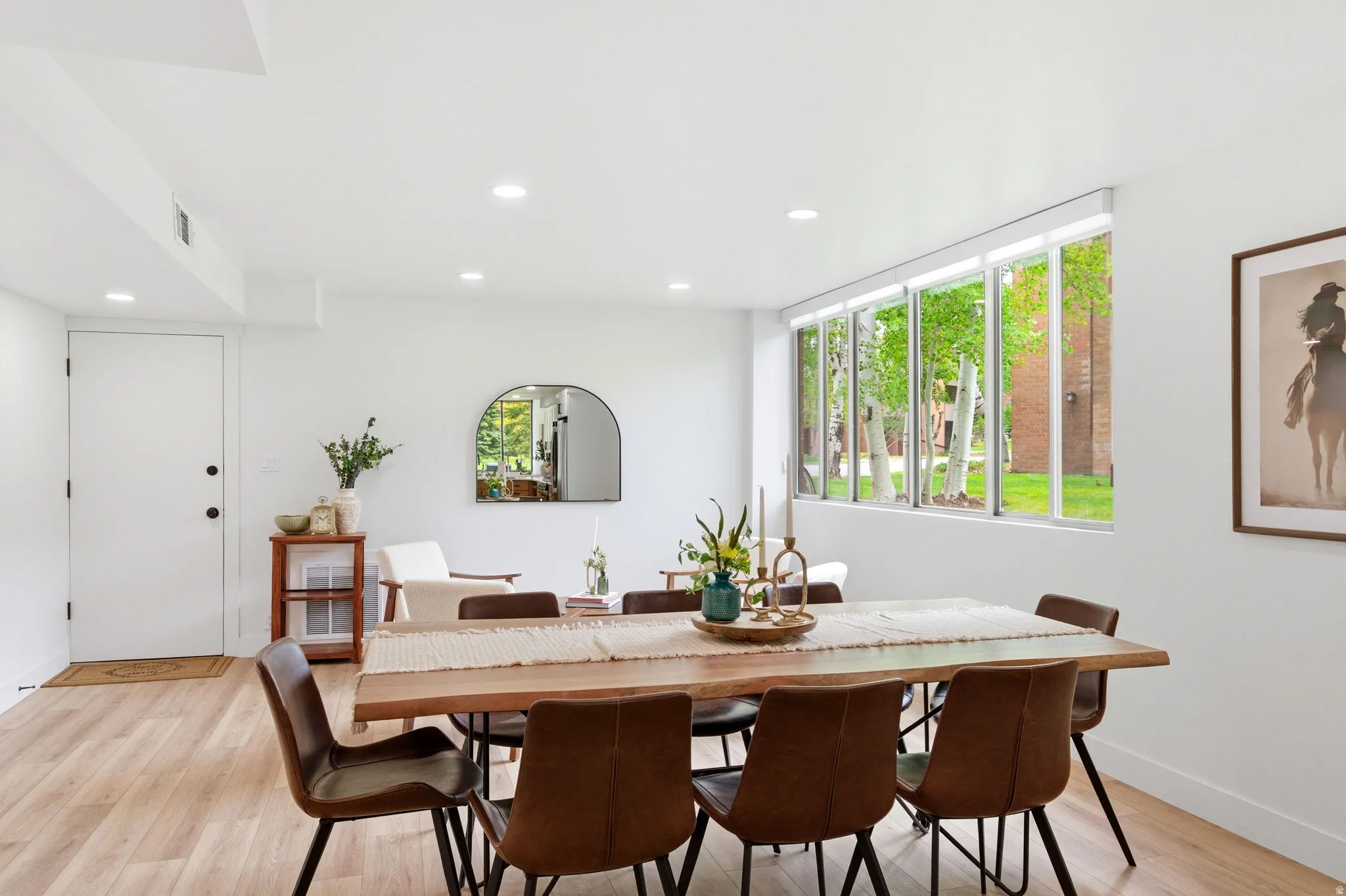 Dining area featuring a live-edge wood table, light wood-finish flooring, and recessed lighting