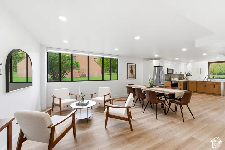 Open-concept living space with wood-finish flooring, recessed lighting, and expansive windows