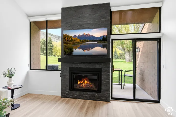 Modern living space anchored by a striking dark brick fireplace with integrated wood-burning insert and flat-screen television mount