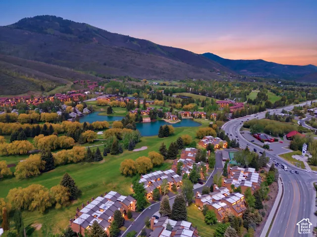 Expansive mountain backdrop with multiple bodies of water, golf course, and mature trees