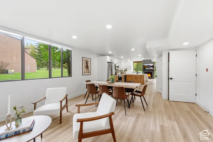 Open-concept living space featuring wood-finish flooring, recessed lighting, and large windows
