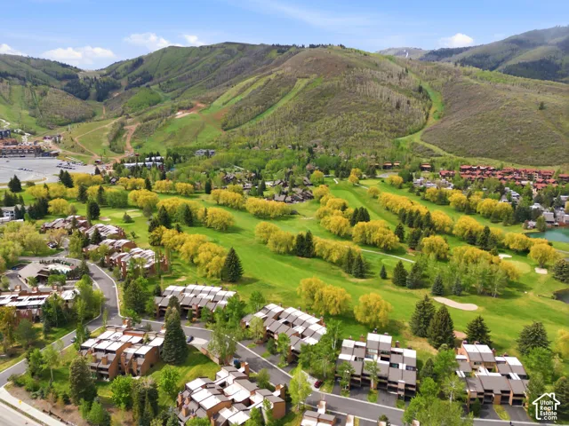 Rolling green hills, golf course fairways, and mature trees define the surrounding landscape