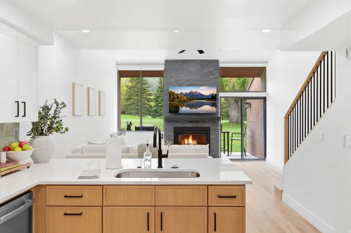 Kitchen island featuring a stainless steel undermount sink, black faucet, and white countertop