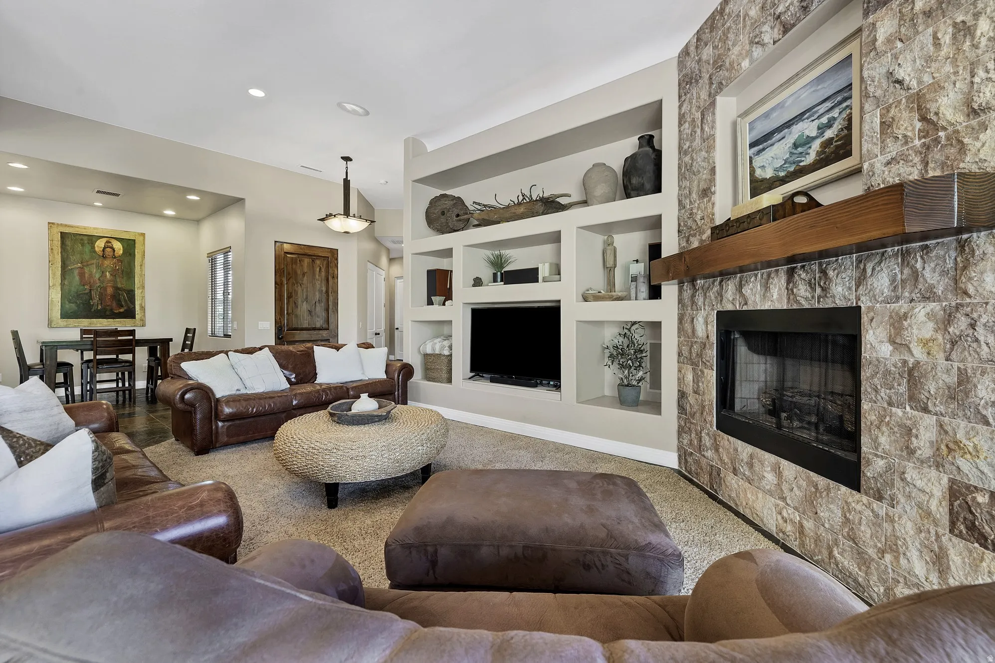 Living area featuring a stone-clad fireplace with a wood mantel