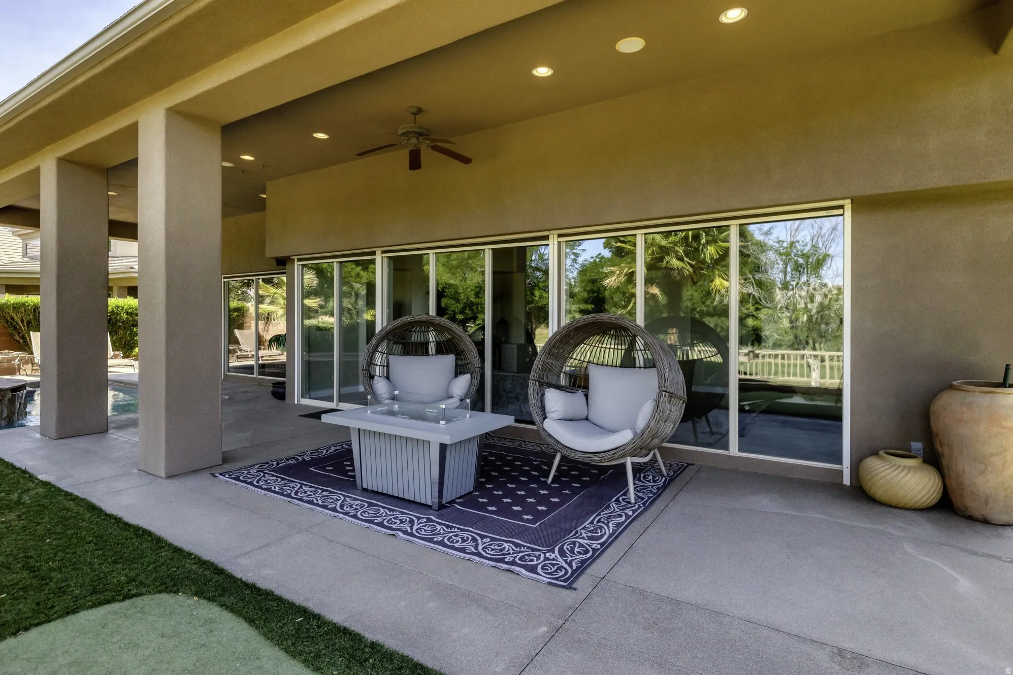 Covered patio featuring recessed lighting, a ceiling fan, and multiple sliding glass doors