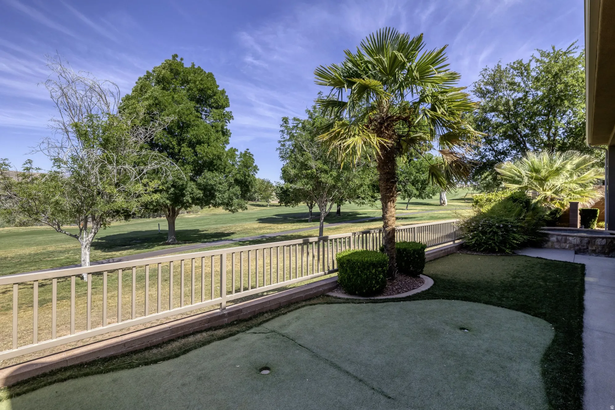 Outdoor putting green complemented by mature palm trees and manicured shrubbery