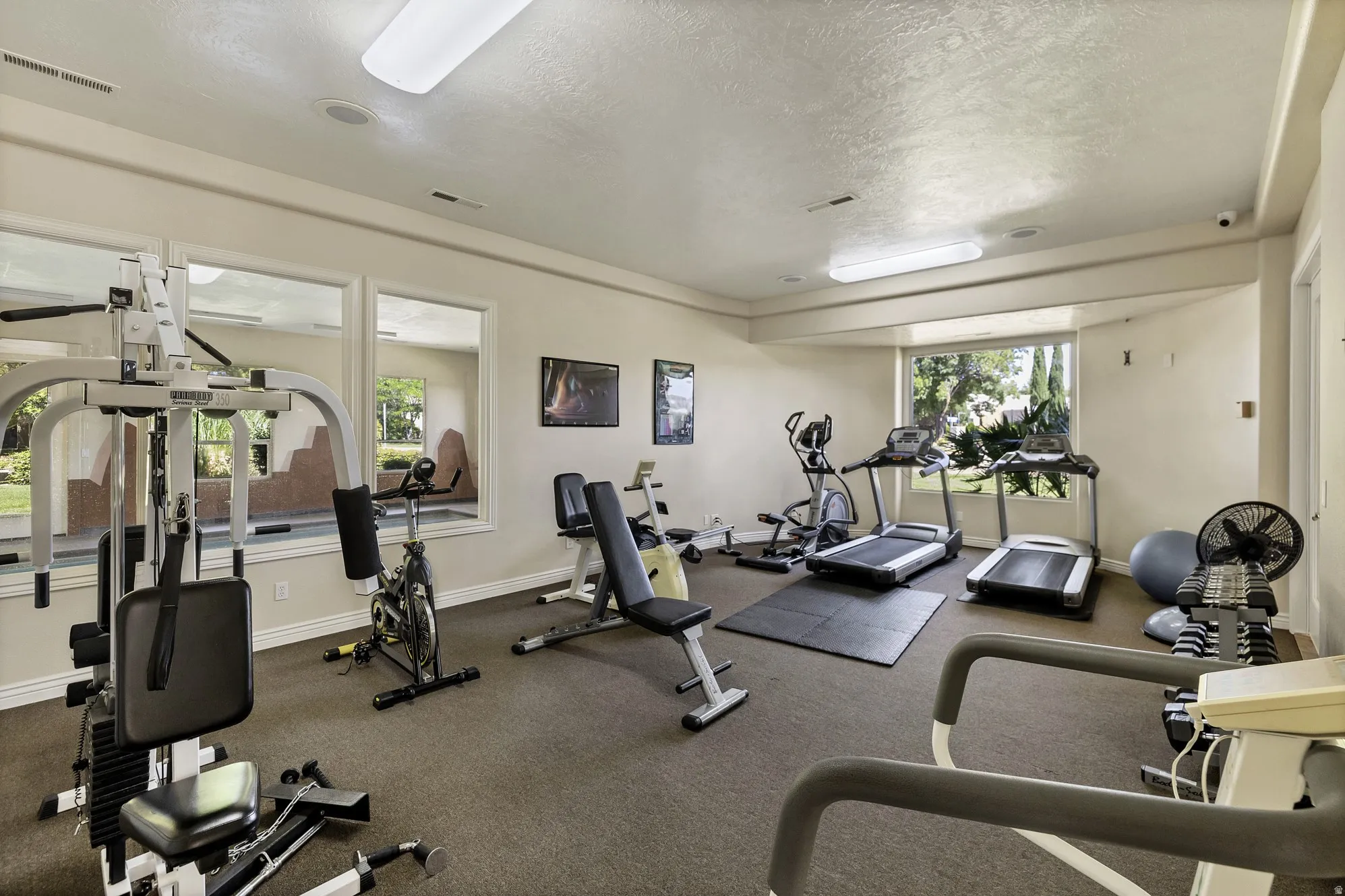Dedicated fitness room featuring recessed lighting and wall-mounted picture frames