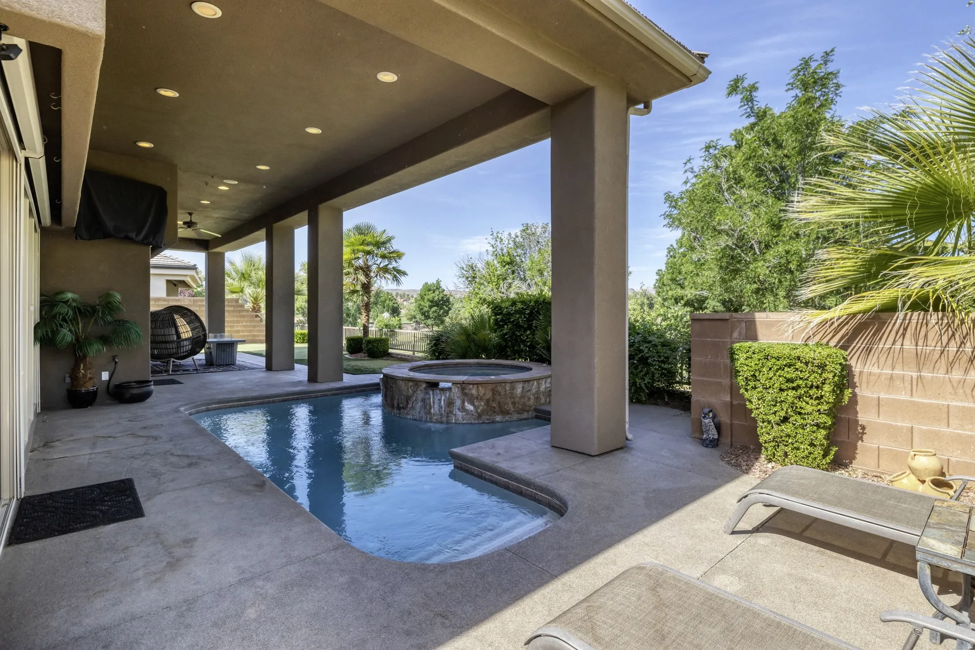Covered patio with recessed lighting, an integrated pool and spa, and a built-in outdoor speaker