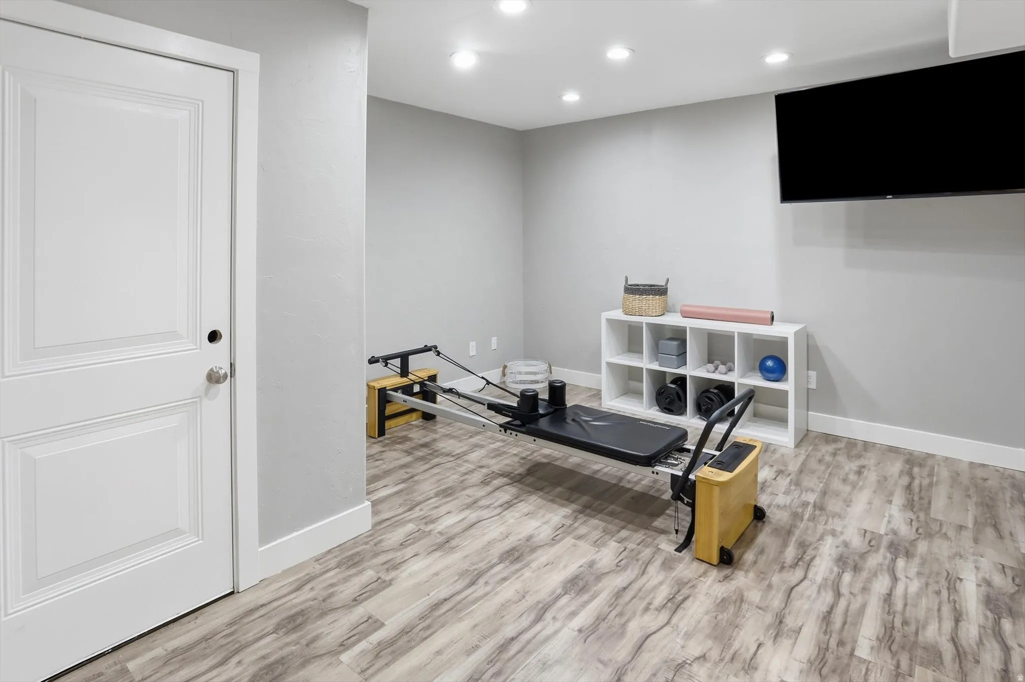 Versatile room featuring wood-finish flooring, recessed lighting, and a neutral wall color
