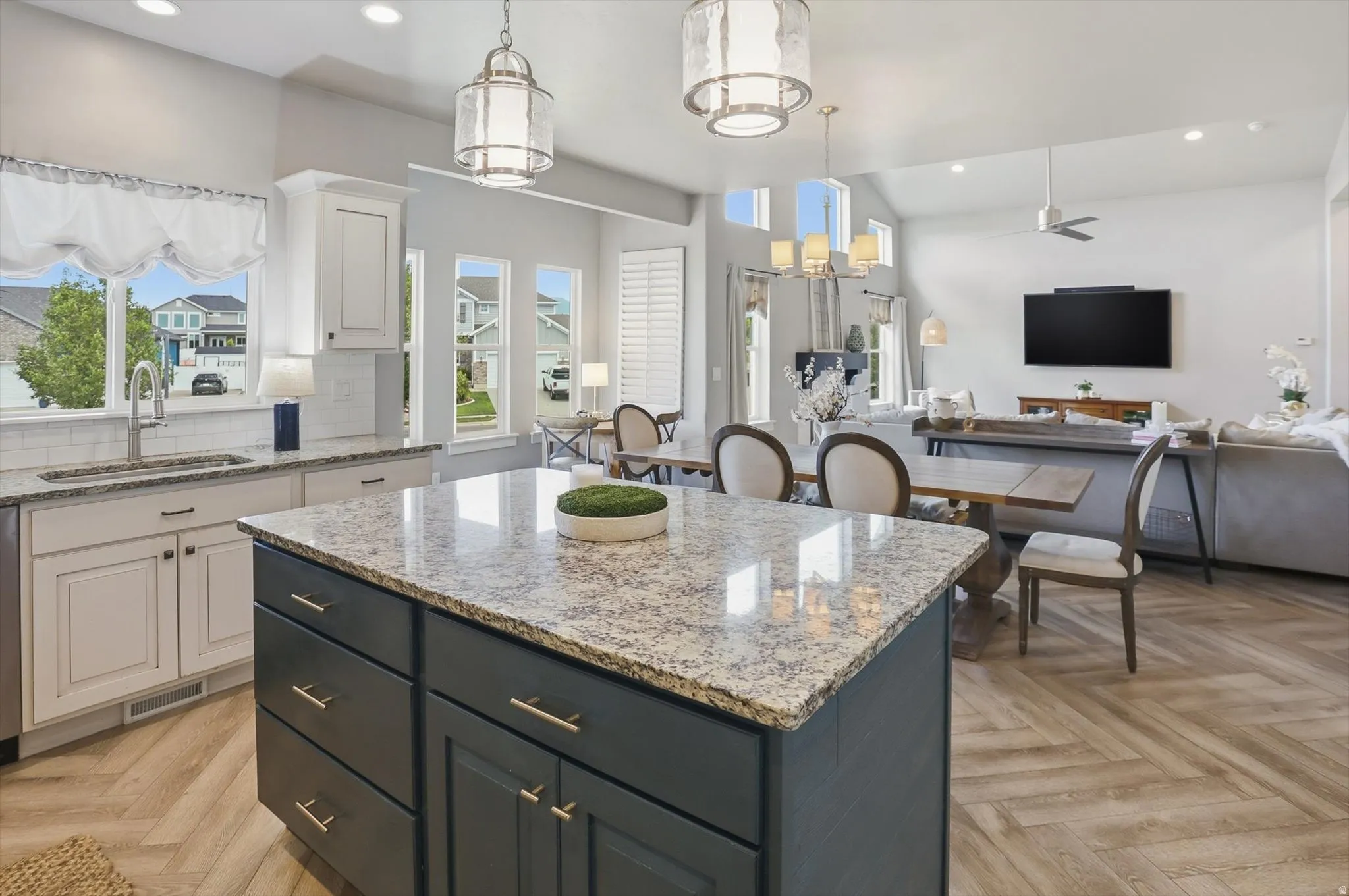 Kitchen island featuring a light-toned granite countertop, dark cabinetry, and gold-finish hardware