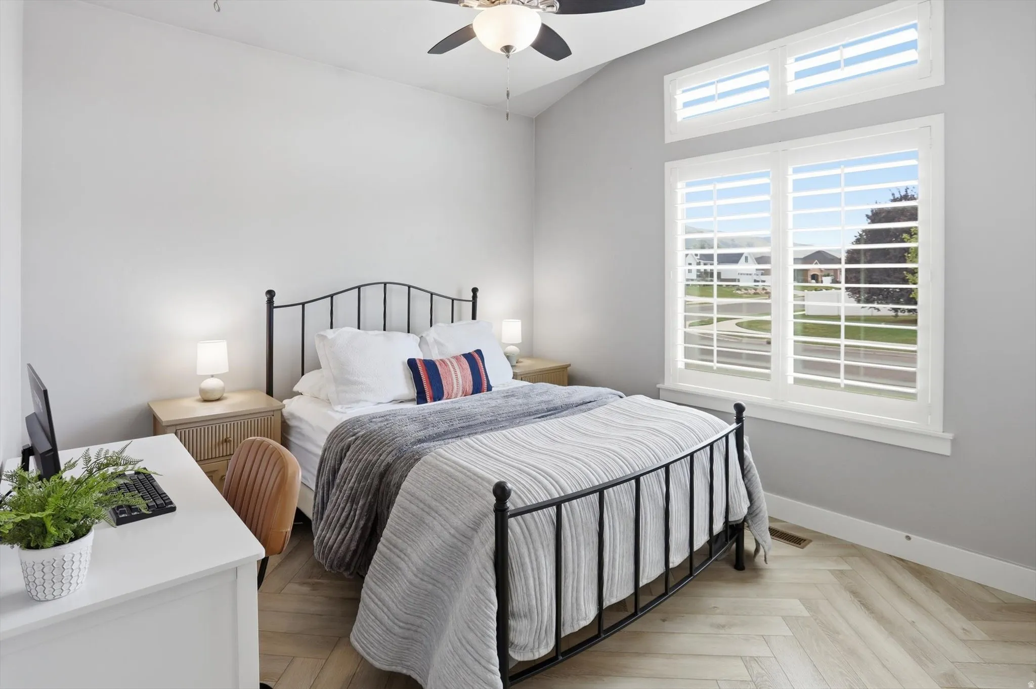 Bedroom #2 featuring vaulted ceilings, herringbone wood-finish flooring, and a ceiling fan