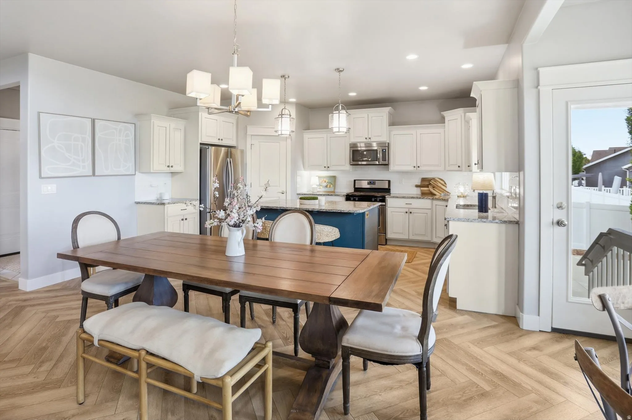 Open concept living space featuring wood-finish flooring in a herringbone pattern