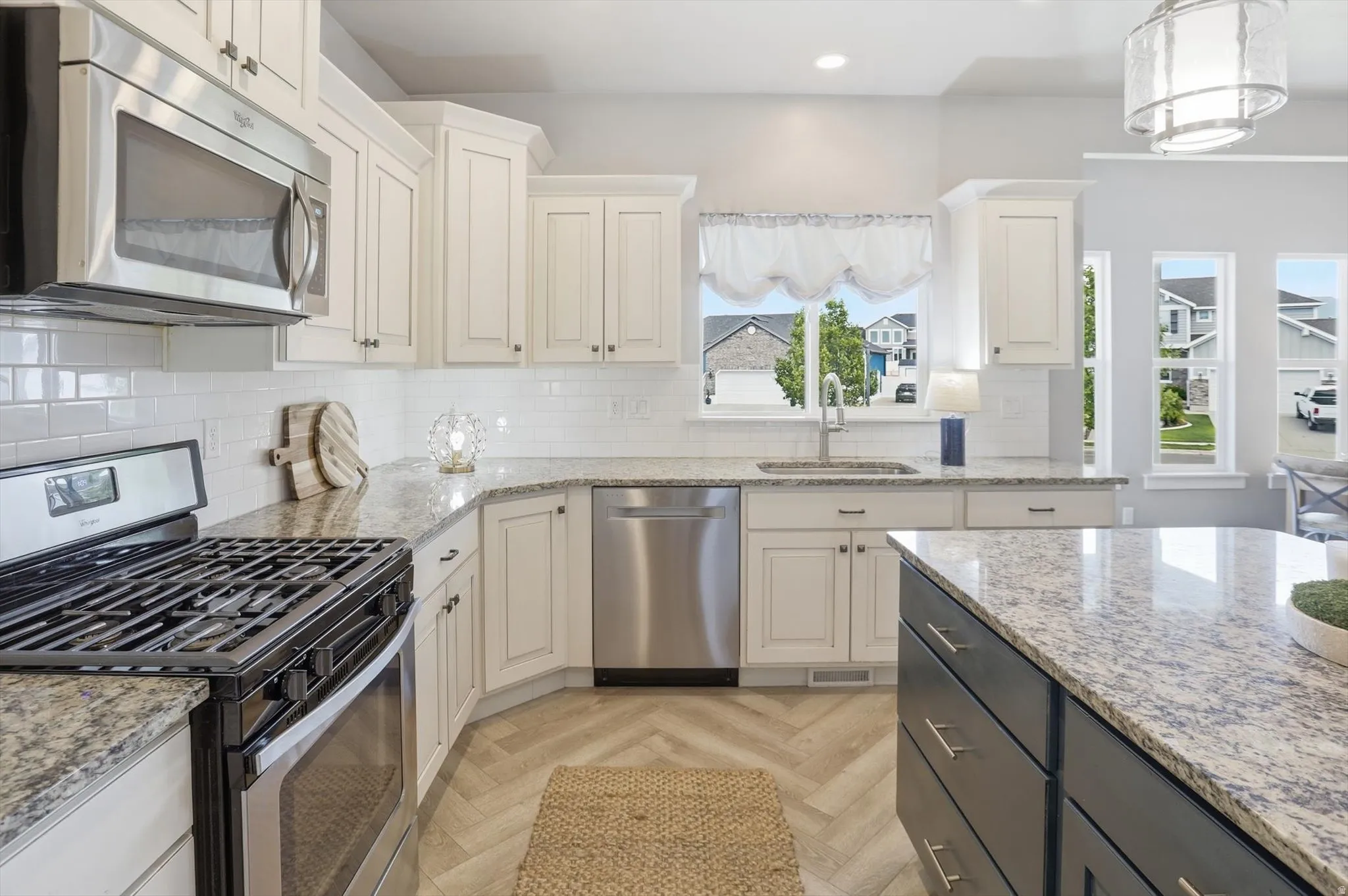 Contemporary kitchen featuring white cabinetry and granite countertops