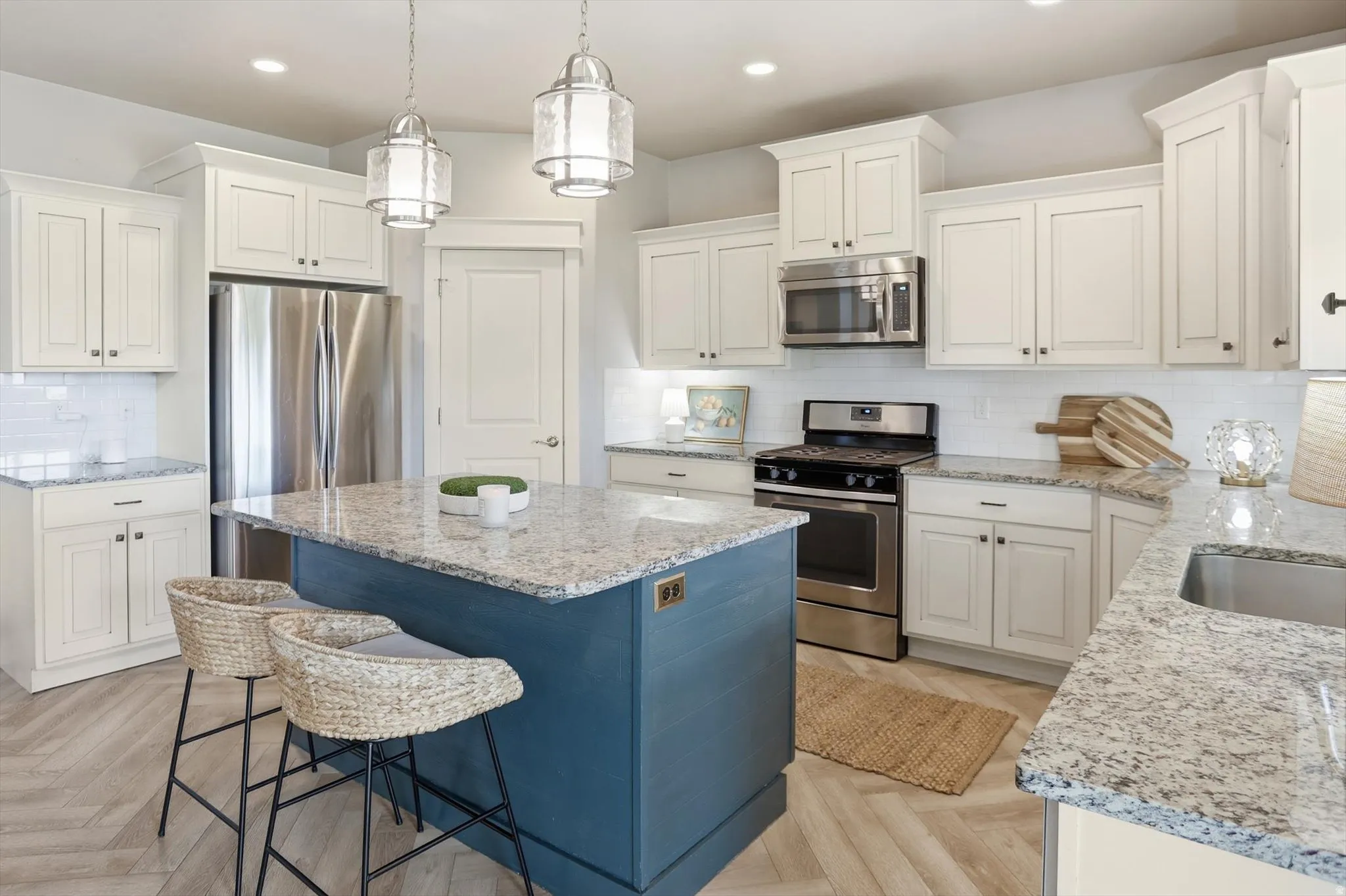 Kitchen featuring a central island with a contrasting base, stone countertops, and stainless steel appliances