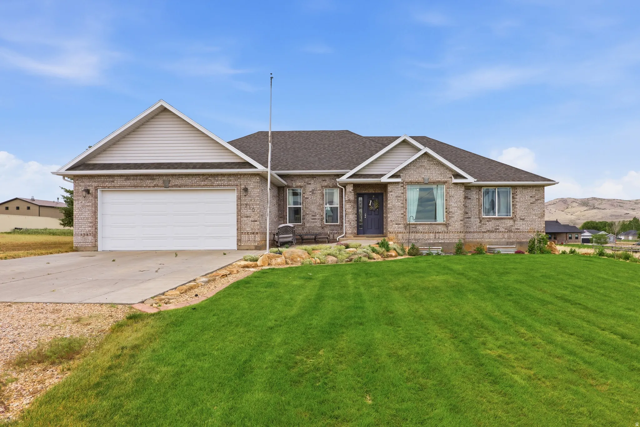 Brick exterior residence with a two-car garage, dark shingle roof, and a prominent front gable