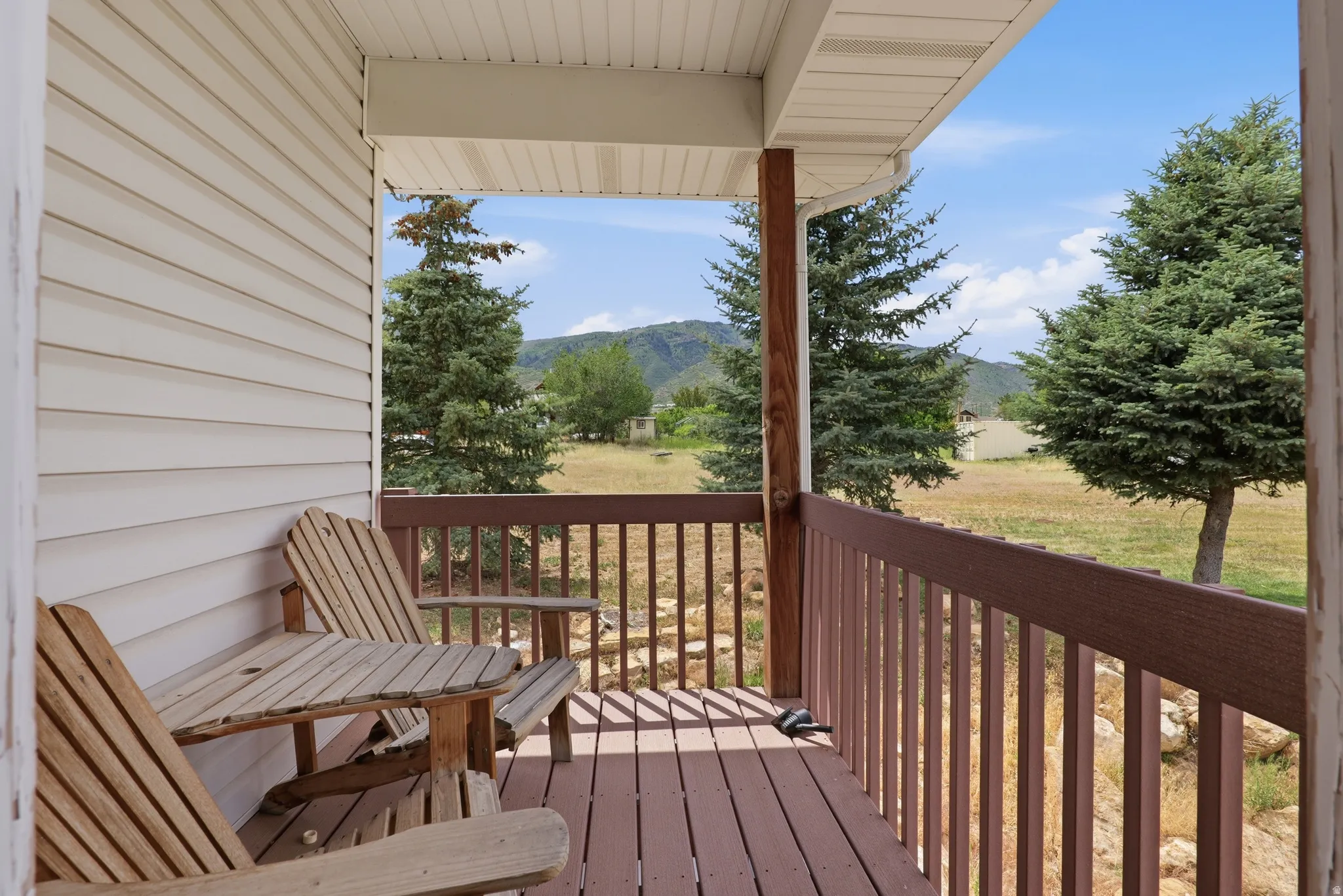 Covered porch featuring brown wood-finish decking and railing