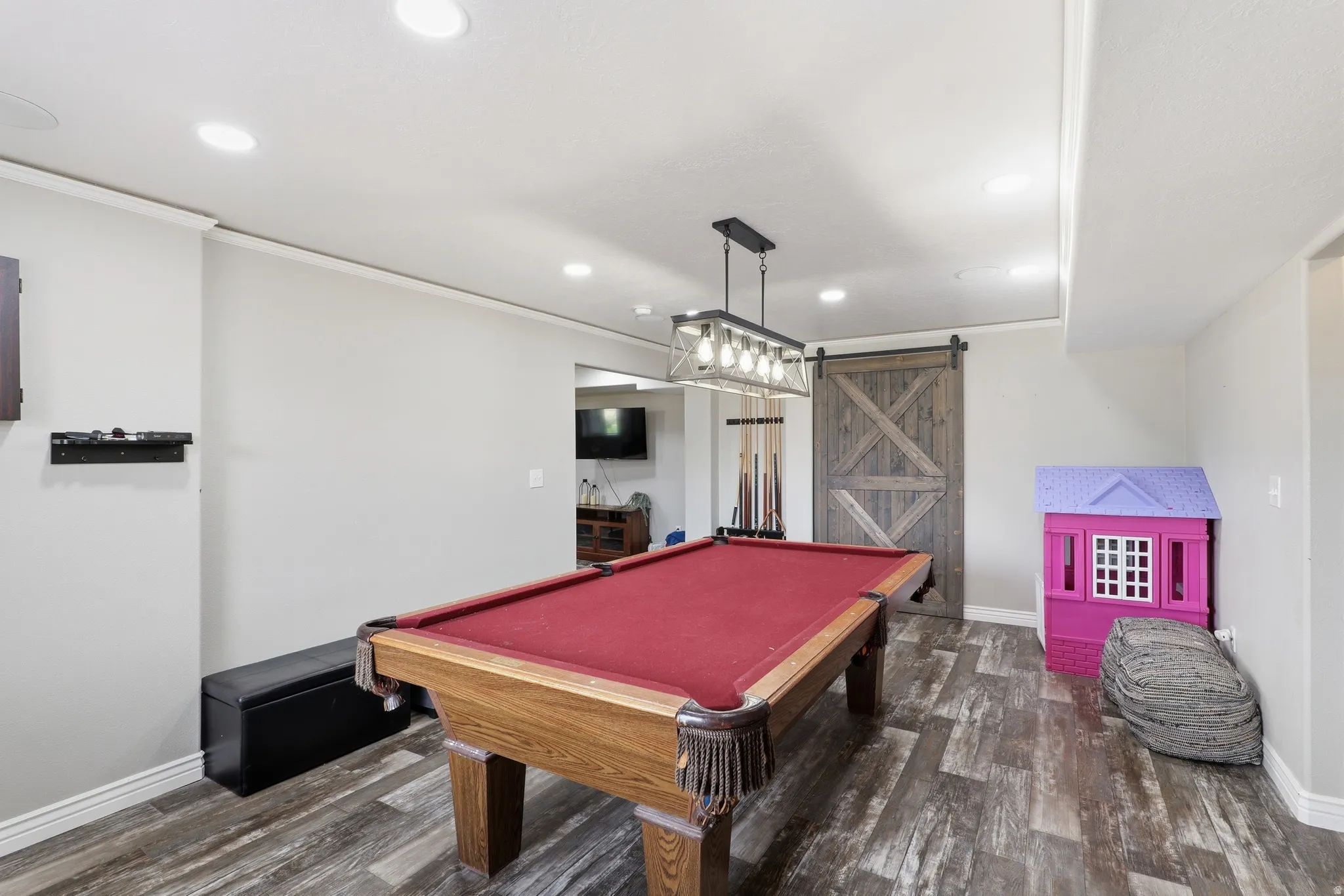 Recreation room featuring wood-finish flooring, recessed lighting, and a barn door