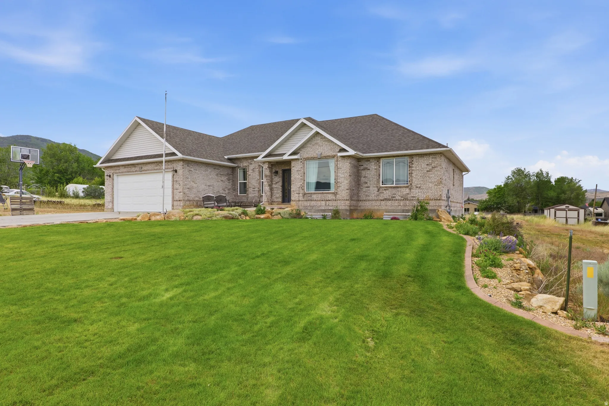 Brick exterior residence featuring a gabled roofline and an attached garage with an automatic door