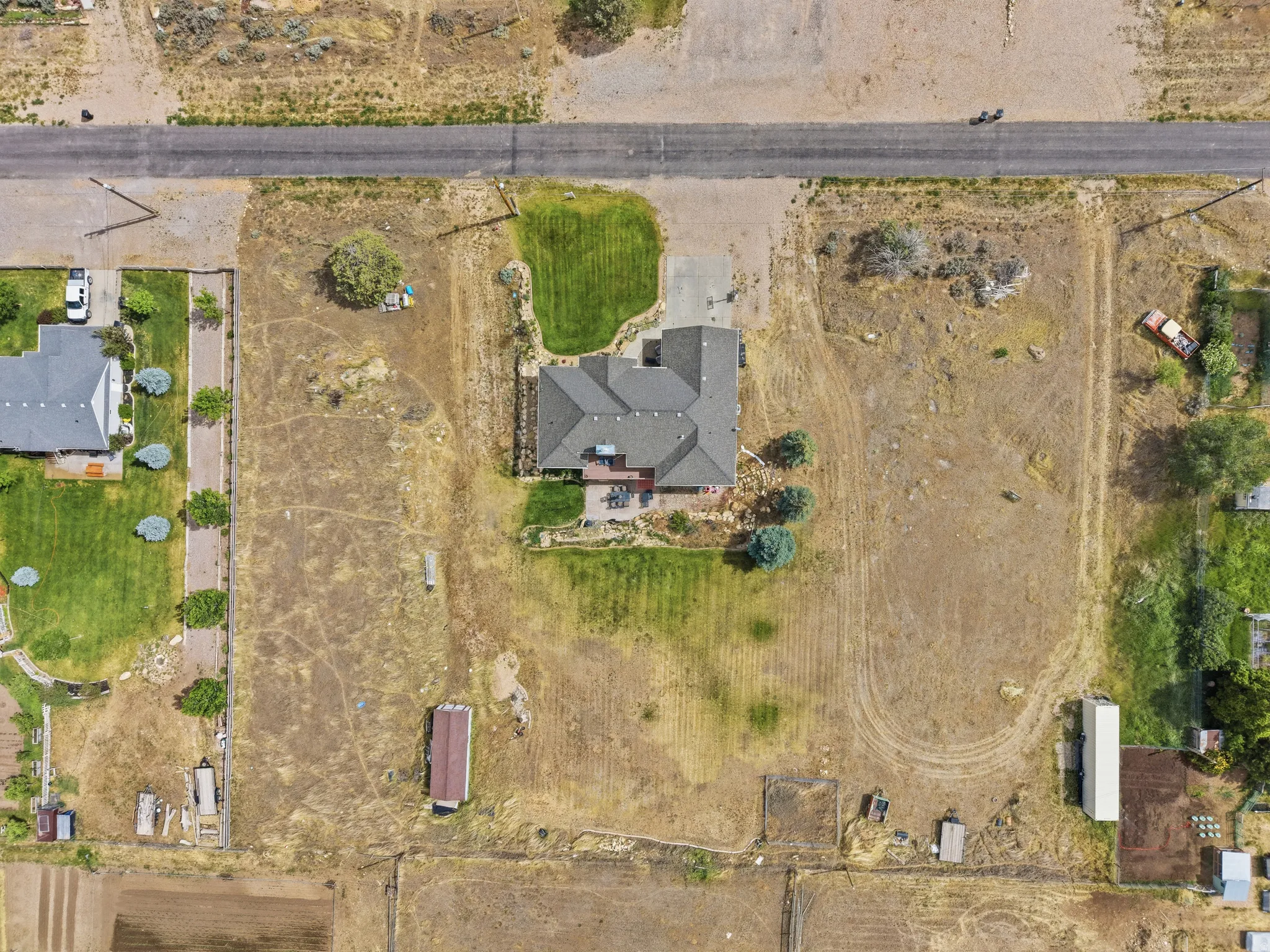 Expansive property featuring a multi-gabled main residence, mature trees, a driveway, and undeveloped land