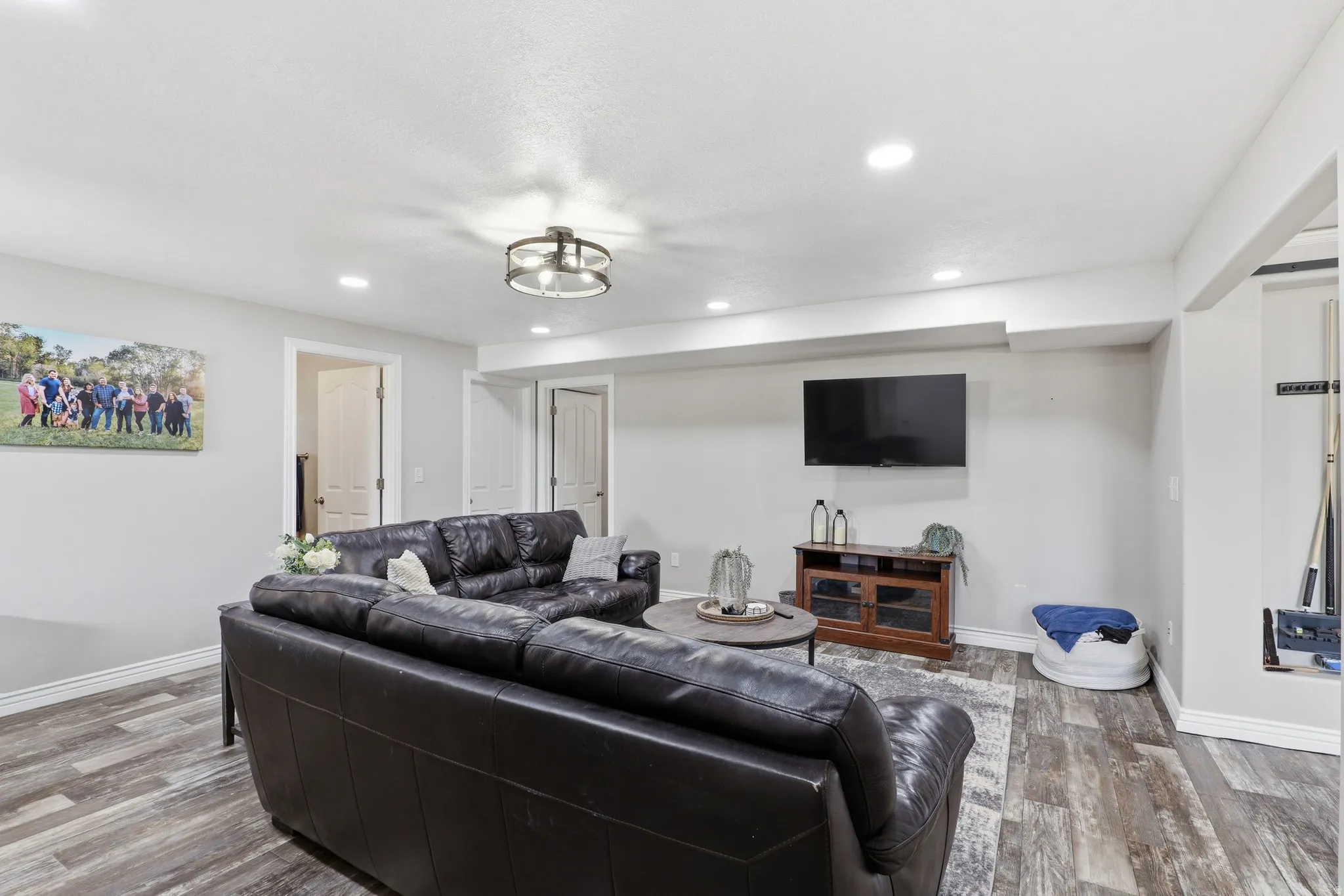 Spacious living area featuring wood-finish flooring, recessed lighting, and a contemporary ceiling fixture