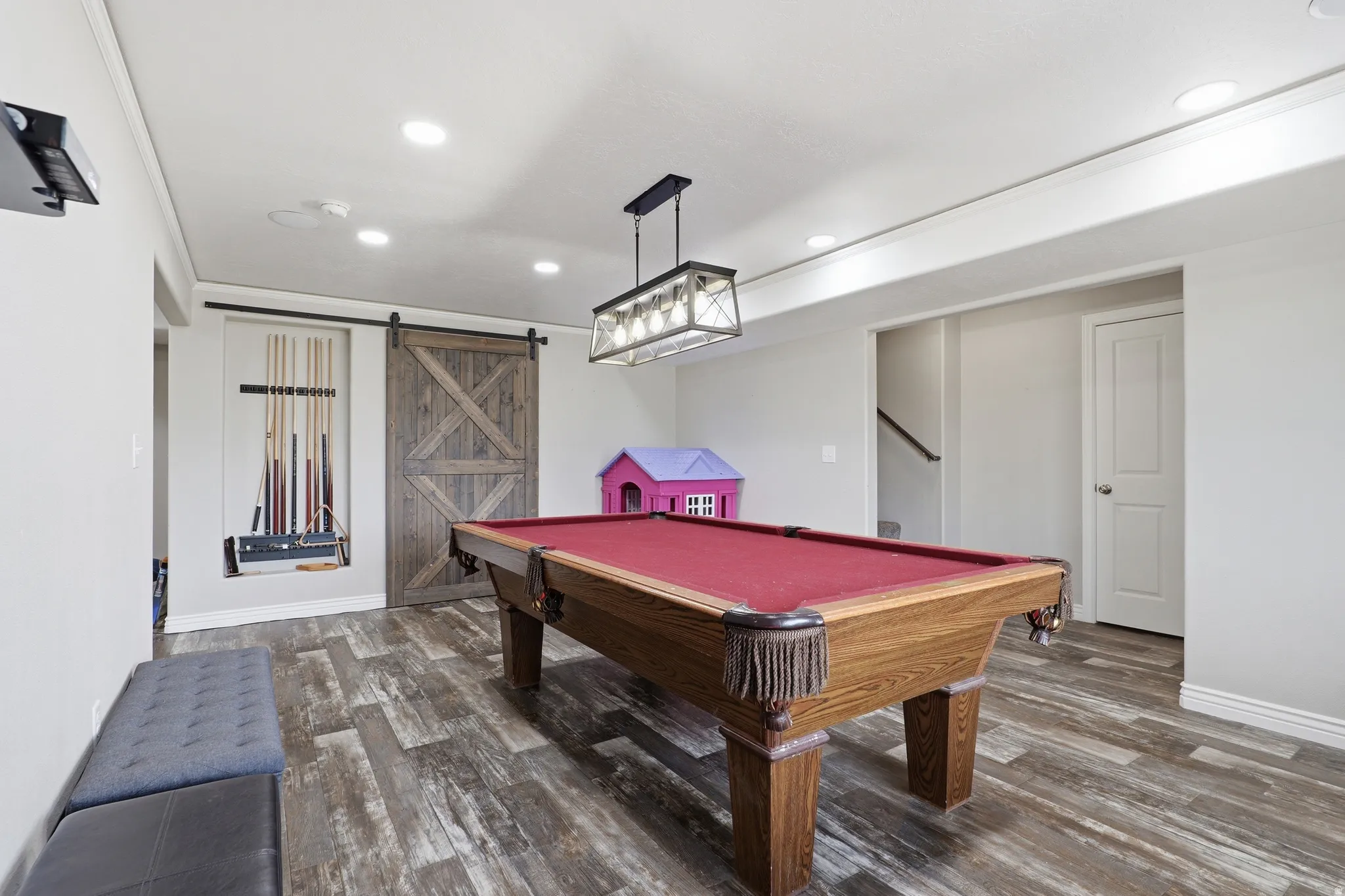 Recreation area featuring wood-finish flooring, recessed lighting, and a rustic barn door
