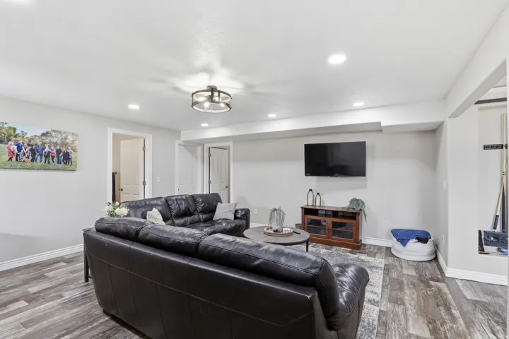 Spacious living area featuring wood-finish flooring, recessed lighting, and a contemporary ceiling fixture