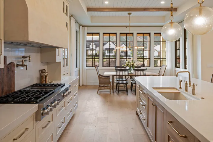 Kitchen featuring stainless steel gas cooktop, hanging light fixtures, light stone countertops, light wood-style floors, and a wooden ceiling with exposed beams